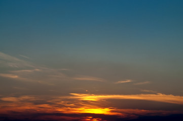 Sunset below thin clouds