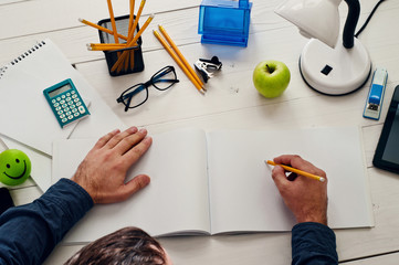 designer sitting at a white wooden desk and working