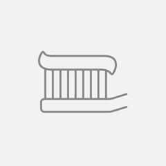 Toothbrush with toothpaste line icon.