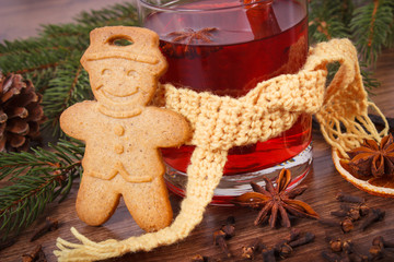 Glass of mulled wine wrapped scarf, gingerbread, spices and spruce branches
