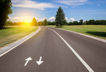 Road and green grass lawn at sunny day