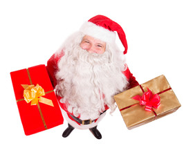 Santa Claus holding Christmas gifts and looking up to camera