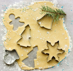 Forms for the Christmas cookies and fresh dough on a white background