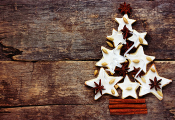 Christmas tree of cookies and spices on vintage wooden background, from above and blank space 