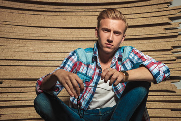 man sitting legs crossed in studio background posing for the cam