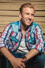 Obraz premium smiling man sitting in studio background looking away
