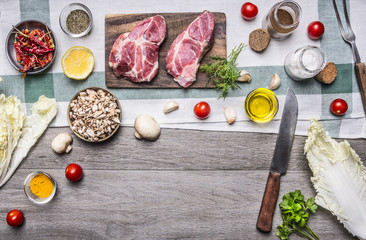 Healthy foods, cooking concept pork steak with vegetables,knife, fruits, spices, laid out by frame place for text, on wooden rustic background top view