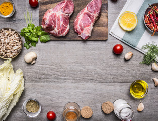 Ingredients for cooking pork steak with vegetables, fruits, spices, laid out by frame,place for text  on wooden rustic background top view