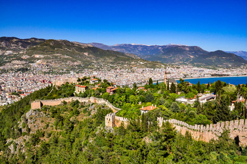 Fototapeta na wymiar Panoramic view on castle walls, lower castle and city from the upper castle in Alanya
