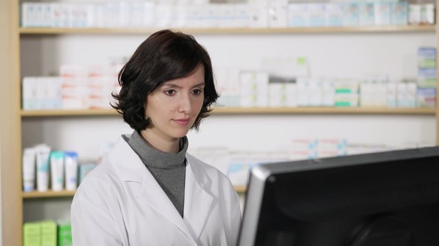 mitarbeiterin in der apotheke schaut auf computer
