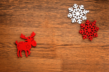 Christmas figurine elk and snowflakes on a wooden background