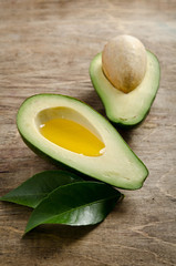 fresh avocado and half of avocado like a bowl for oil on wooden © Soyka