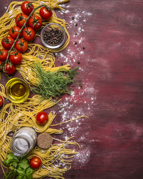 Delicious assortment of ingredients for cooking pasta with tomatoes, flour, butter, black pepper, herbs and salt on wooden rustic background top view border ,with text area