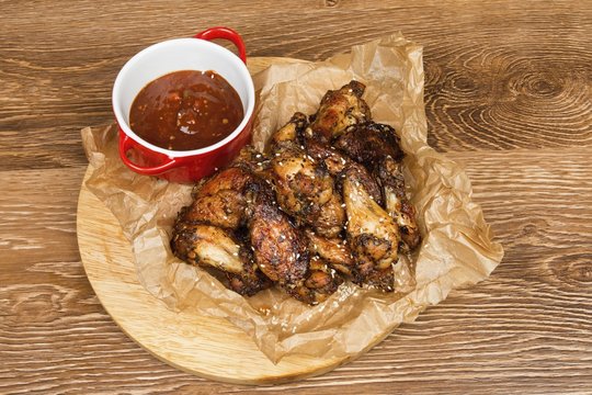 Chicken wings with  sauce on wooden table.