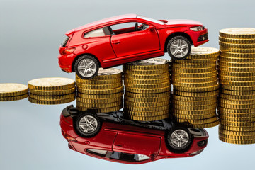 Steigende Autokosten. Auto auf Münzen
