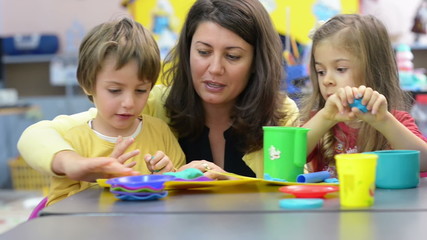 Kids playing with plasticine at kindergarten - Powered by Adobe