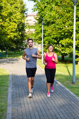 Portrait of cheerful caucasian couple running in the park