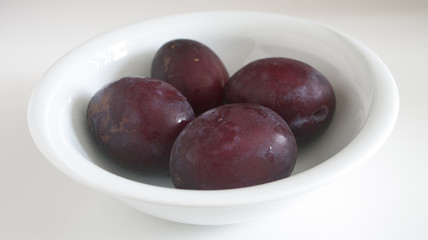 Plums close up on white