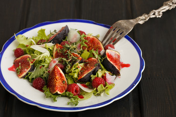 Salad with figs and raspberries, dressed with raspberry sauce and Parmesan cheese