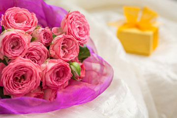 Wedding bouquet of pink roses in a beautiful lilac packaging with gift box for jewelry