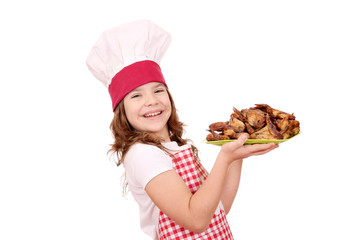 happy little girl cook with roasted chicken wings