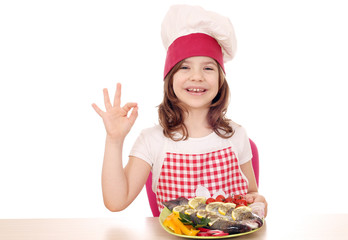 happy little girl cook with trout and ok hand sign