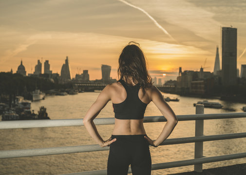 Athletic young woman on bridge at sunrise