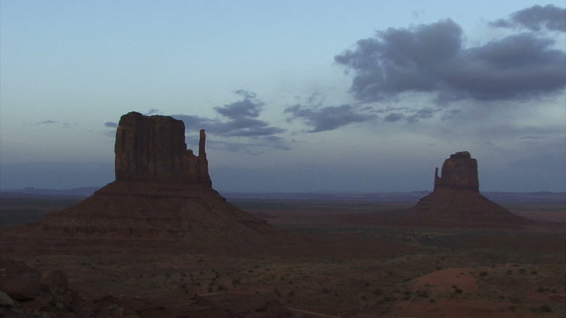 Time Lapse 2053: Wispy time lapse clouds travel over Monument Valley as night falls.