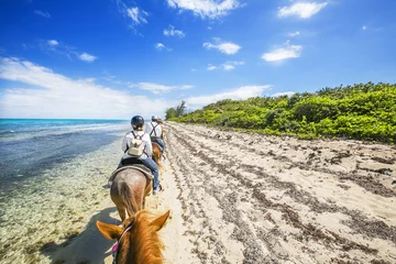 Behang Caraïben People riding on horse back at the Caribbean beach. Grand Cayman