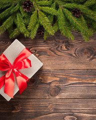 Fir tree and gift box on dark wooden background