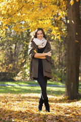 Beautiful happy woman walking in autumn park. Fall season