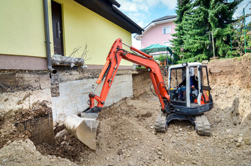 A family house is being rebuilt with the help of an excavator