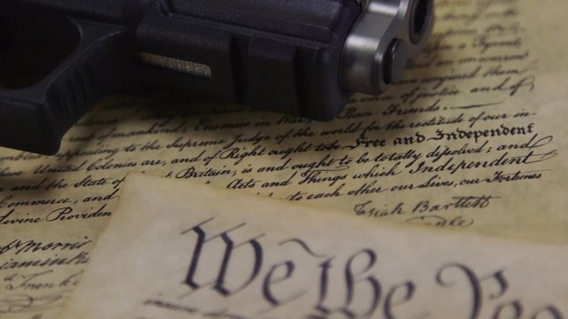 US Constitution Bill of Rights with hand gun - History of the Second Amendment