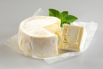 Soft Cheese with Cut Wedge and Fresh Basil