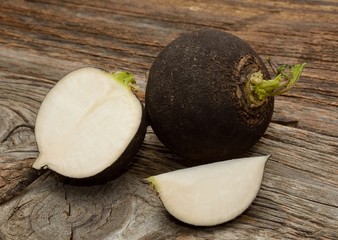 Black radish on wooden background