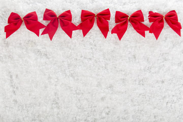 Christmas red bow on a background of white snow