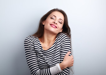 Happy young casual woman hugging herself with natural emotional