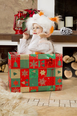 Fototapeta na wymiar little girl in pajamas hiding in a box for gift