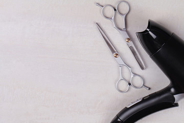 Scissors and hair dryer on white wooden background. Hairdresser salon concept. Haircut accessories