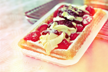 Tourists sharing Brussels delight – gaufre or wafer with cream and fruits
