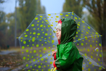 Toddler and umbrella in autumn rainy park