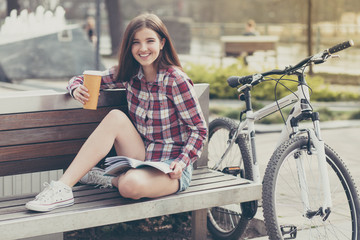 Fototapeta na wymiar Young woman drinking coffee on a bicycle trip