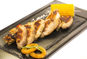 chicken wings are grilled on a wooden platter