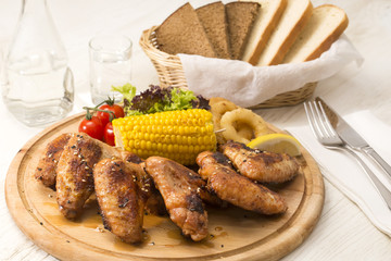 chicken wings are grilled on a wooden platter