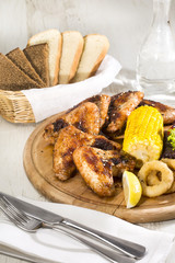 chicken wings are grilled on a wooden platter