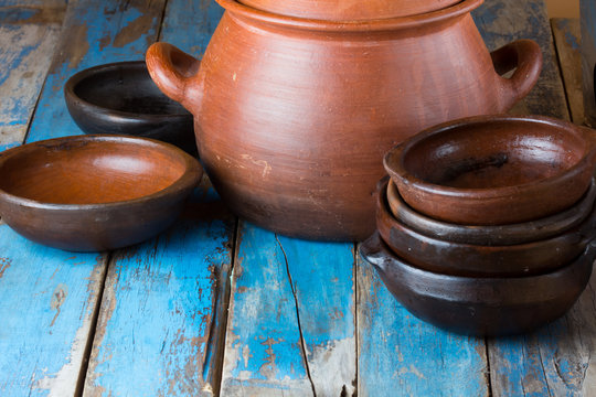 Clay pot and plates on wooden old background