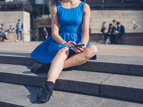 Young woman using her smart phone in the city