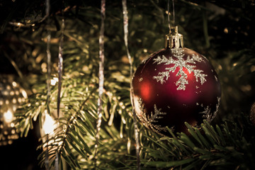 Matt rote Christbaumkugel mit Schneeflockenmuster am Weihnachtsbaum