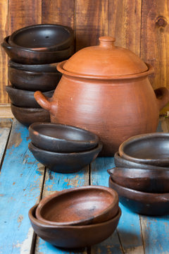 Clay plates and pot on wooden old background