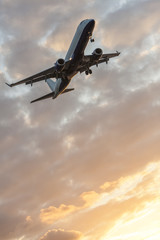 Fototapeta na wymiar Airplane Flying at Sunset or Sunrise